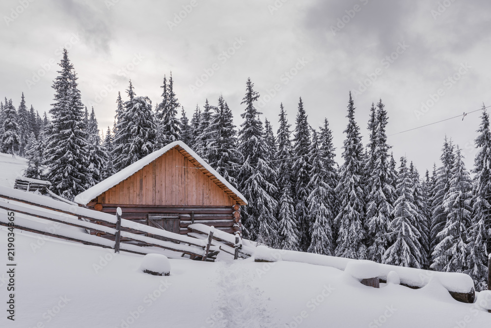 Fantastic winter landscape with wooden house in snowy mountains. Christmas holiday concept. Carpathians mountain, Ukraine, Europe Fantastic winter landscape with wooden house in snowy mountains. Christmas holiday concept. Carpathians mountain, Ukraine, Europe