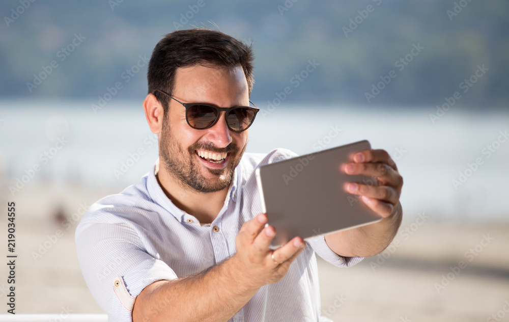 Man with tablet enjoying beside river