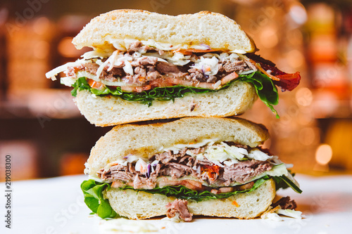 Two stacked roast beef sandwich halves. photo