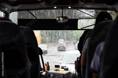 Bad weather outside, bus with passengers, view from inside to street through the window