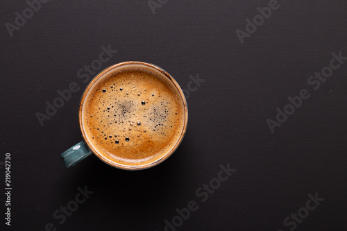 Cup of coffee on black background. Copy space. Top view. Flat lay.