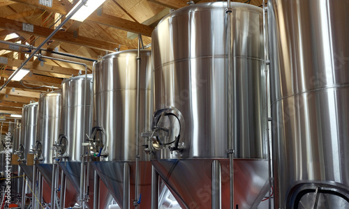Row of shiny metal micro brewery tanks. photo