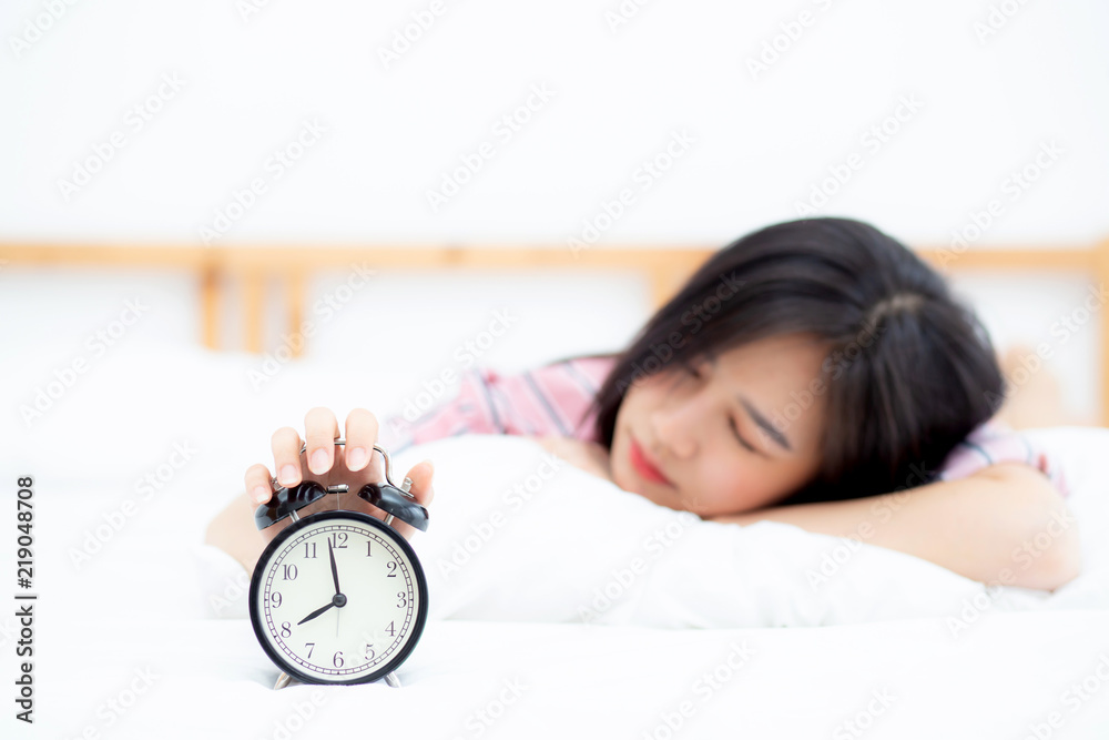 Beautiful asian young woman turn off alarm clock in morning, wake up for sleep with alarm clock, relax and lifestyle concept. Beautiful asian young woman turn off alarm clock in morning, wake up for sleep with alarm clock, relax and lifestyle concept.