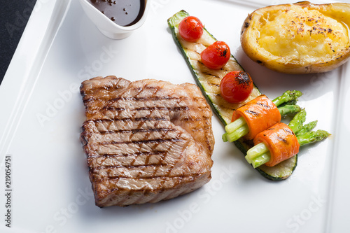 Close up Hida beef steak with grilled tomato, carrot, cucumber and asparagus on white plate photo