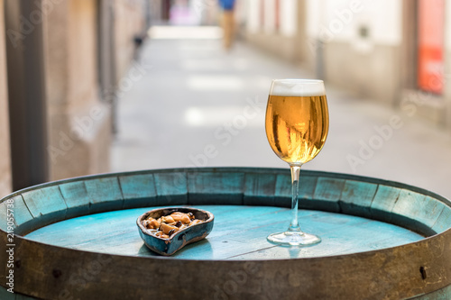 A glass with beer and mussels on a wooden wine barrel as a table. © Ruben