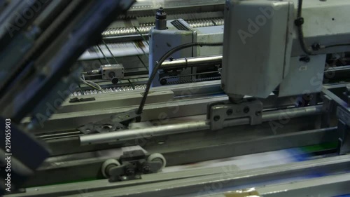 In the press office the machine moves newspapers and magazines on the production tape. Closeup