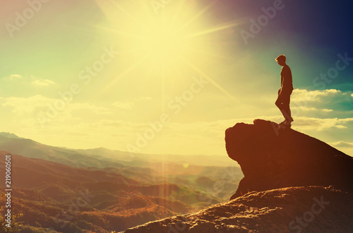 Photo Man walking on the edge of a cliff high above the mountains