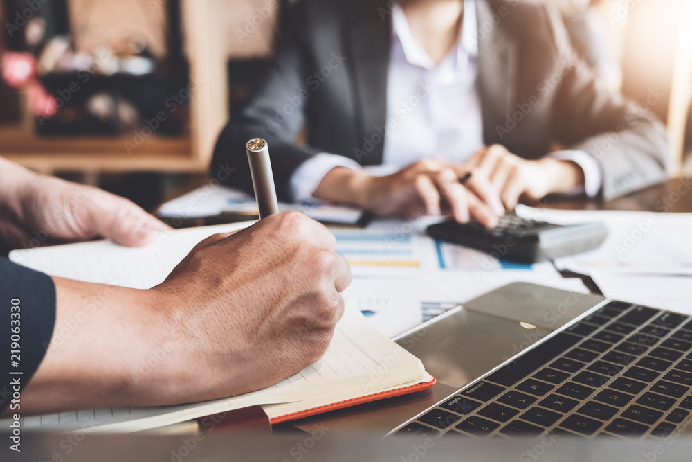 Close up Businessman and partner using calculator and laptop for calaulating finance, tax, accounting, statistics and analytic research concept Close up Businessman and partner using calculator and laptop for calaulating finance, tax, accounting, statistics and analytic research concept