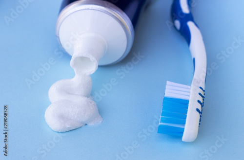 Toothpaste squeezed out from tube on blue background. Dental hygiene concept.