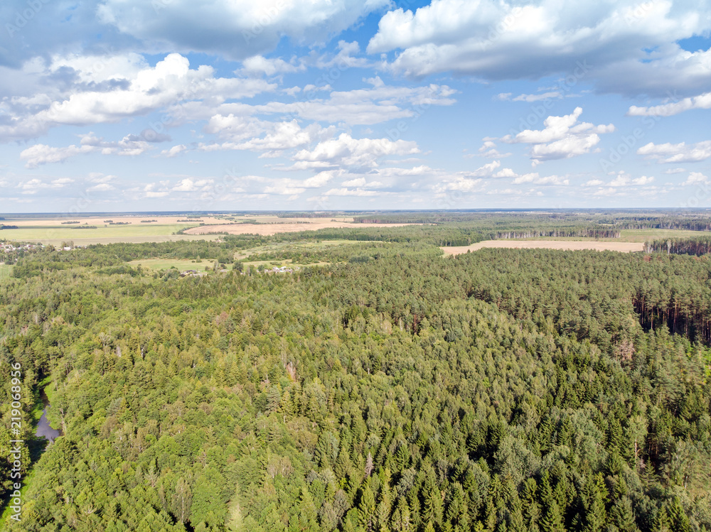 nature landscape aerial photography. foliage forest, green fields and cloudy blue sky 