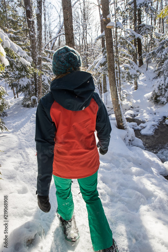 Beautiful woman snowshoeing in the forest.