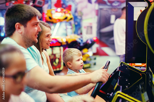 Cute girl plays a rifle shoots arcade in game machine at an amusement park.