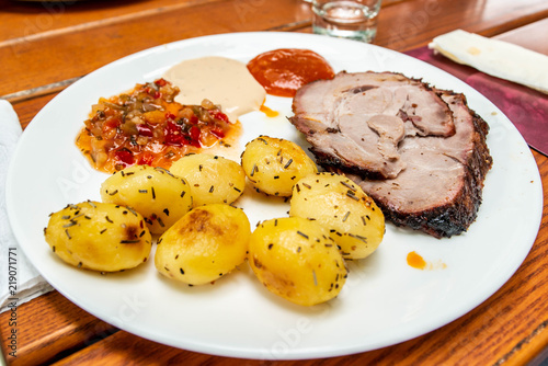 Fried mini potatoes with rosmarine and vegetables on a white plate photo