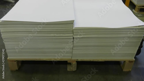 Big sheets of paper lie on a pallet. Panning the camera.