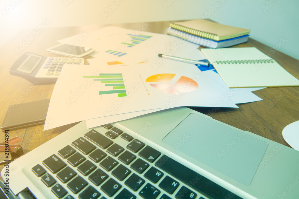 Fototapeta premium Business documents on office table with laptop, smart phone and graph financial. Business concept.