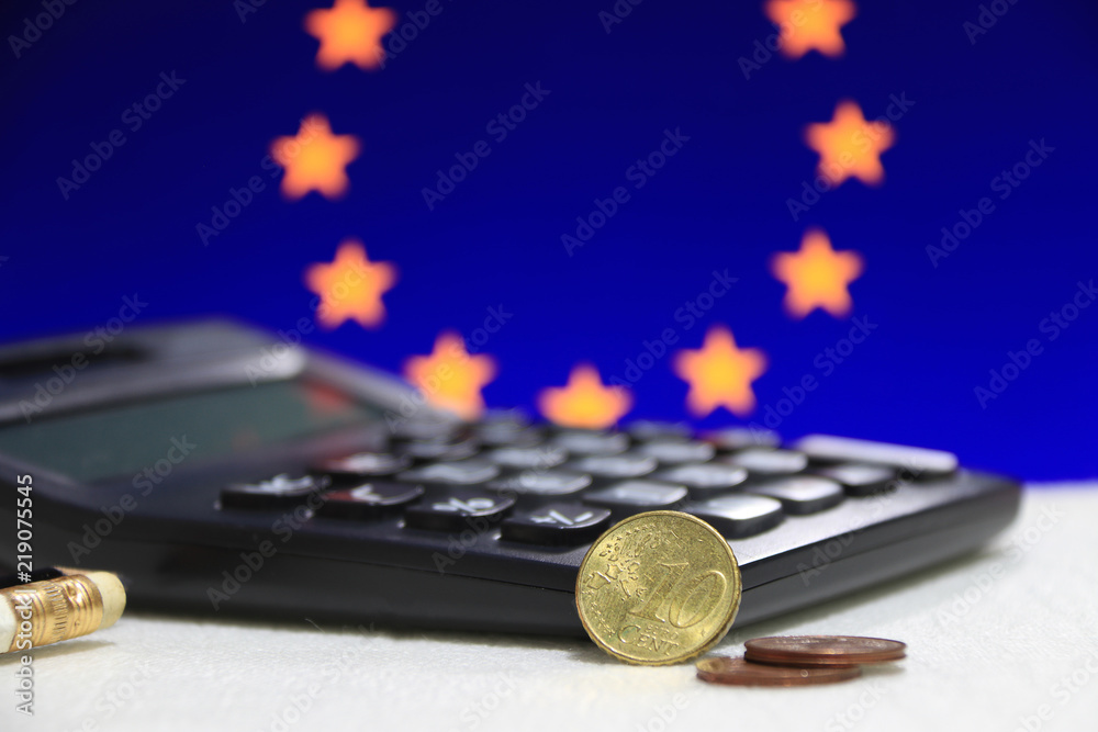 Ten Germany euro cent on reverse and two coin of two euro cent on white floor with black calculator and pencil, Euro flag background, the concept of finance.