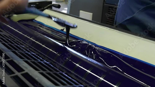 A large printing machine throws paper into a container.