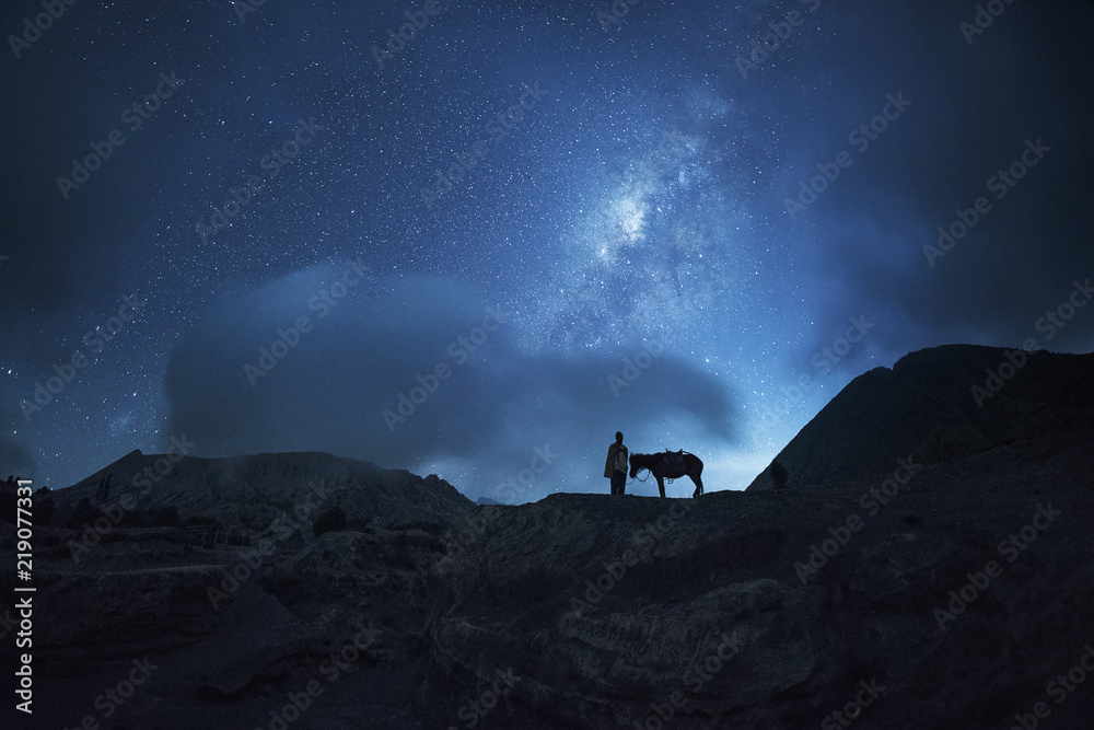 custom made wallpaper toronto digitalHorsemen standing under million stars in sky with his horse near smoking hot volcano Mount bromo at night, Indonesia
