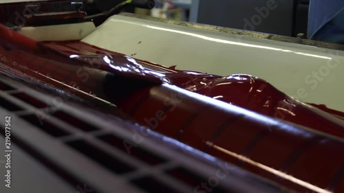 A large printing machine throws paper into a container.