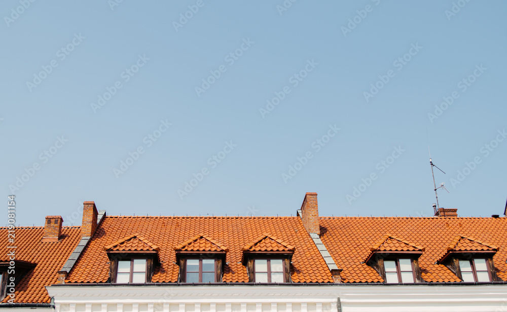 Old beautiful windows in roof covered with orange slate, copy space