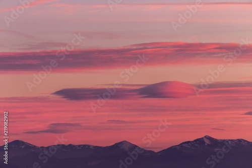 A view of some mountains top  beneath a beautiful  warm colored sky at sunset