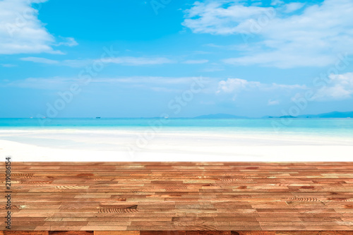 Perspective wooden table on top over blur sea in sunny day background. Beautiful sea and clouds in Thailand on summer, can be used mock up for montage products display or design layout.