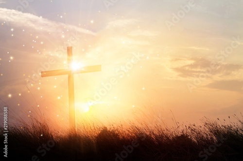 Fototapet Silhouette christianity cross on grass field in sunrise background