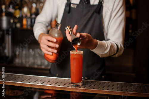 Bartender pourring a bloody mary into the classical cocktail glass