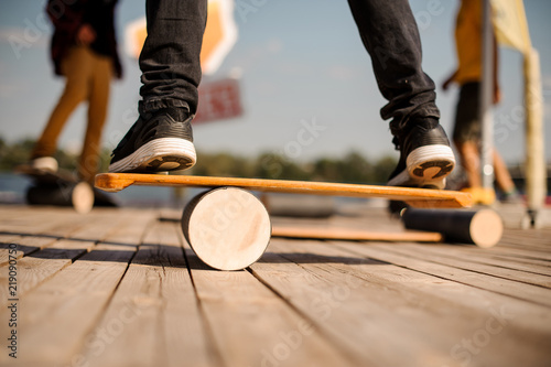 Man standing on the balance board on the wooden pier photo