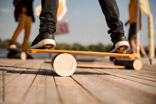 Man standing on the balance board on the wooden pier