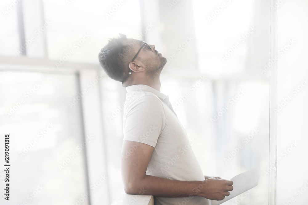Junger Mann in einem Büro stehend Junger Mann in einem Büro stehend