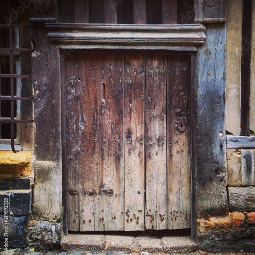 Ancient weathered wooden doorway in Honfleur, Normandy, France. Mobile phone photo with some phone or tablet post processing.