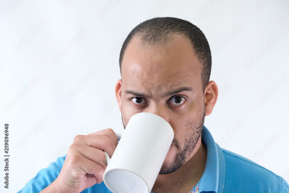 Man in blue t-shirt expressive face mug of coffee Man in blue t-shirt expressive face mug of coffee