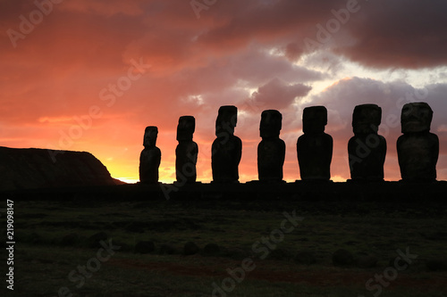 Silhouette of huge Moai statues of Ahu Tongariki against beautiful sunrise cloudy sky, Easter Island, Chile, South America 