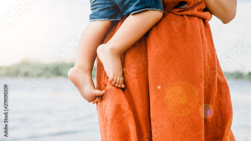 cropped image of mother holding son near river
