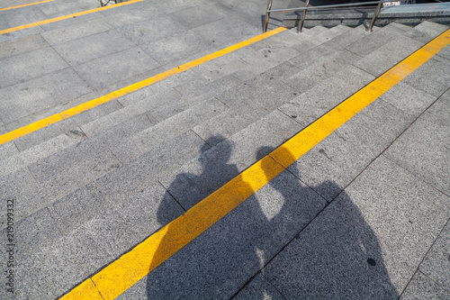 two human shadows fall on stone staircase