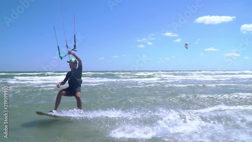 The happy man is engaged in kitesurfing and shows a finger photo