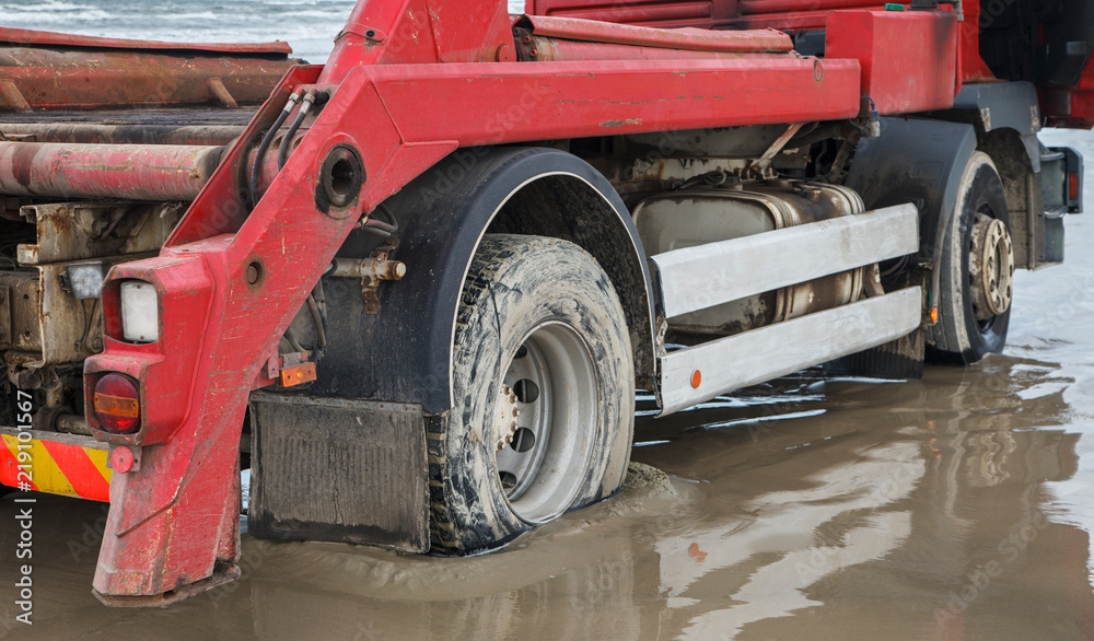 Heavy car sink into sand.