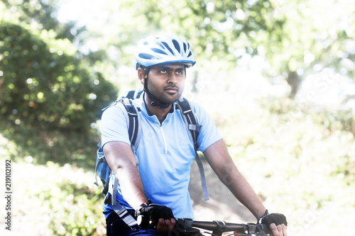 Junger Mann mit Helm und Trikot und Fahrrad