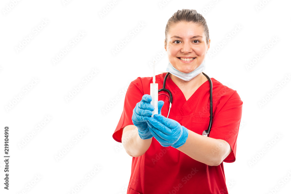 Young medical nurse wearing red scrub showing syringe. Young medical nurse wearing red scrub showing syringe.