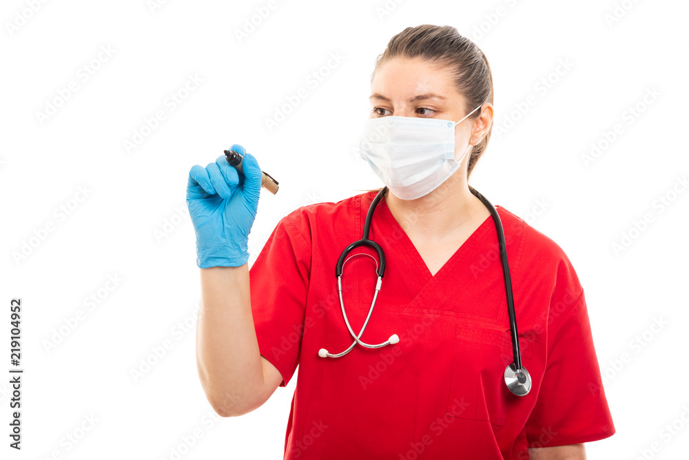 Young medical nurse wearing red scrub using black marker. Young medical nurse wearing red scrub using black marker.