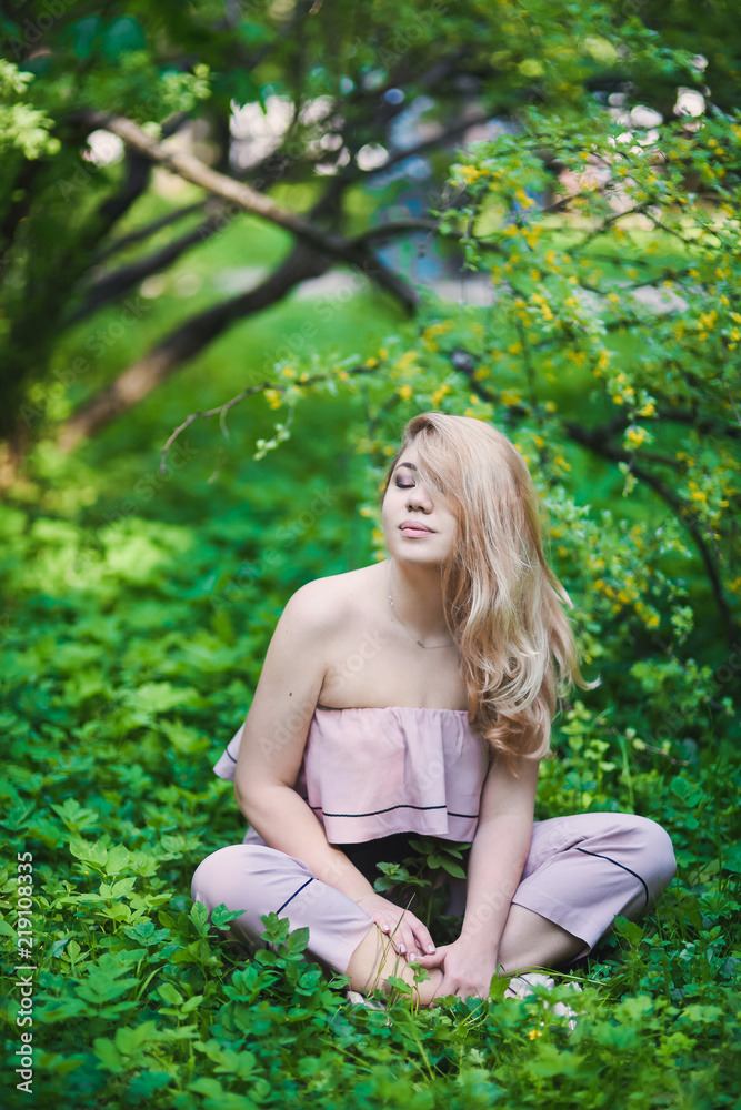 Portrait Beautiful young blonde girl with puffy lips and sexy feminine body posing in the green park on sunny day Portrait Beautiful young blonde girl with puffy lips and sexy feminine body posing in the green park on sunny day