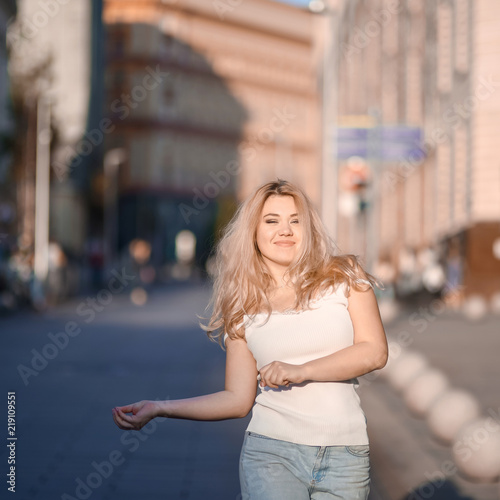 Portrait Beautiful young blonde girl in sunglasses with puffy lips and sexy feminine body posing on the street style on sunny day 