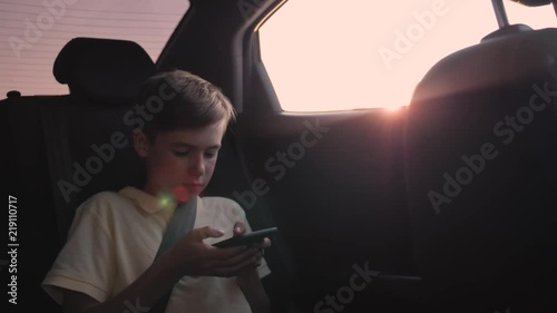 teen inside the car playing on the smartphone photo