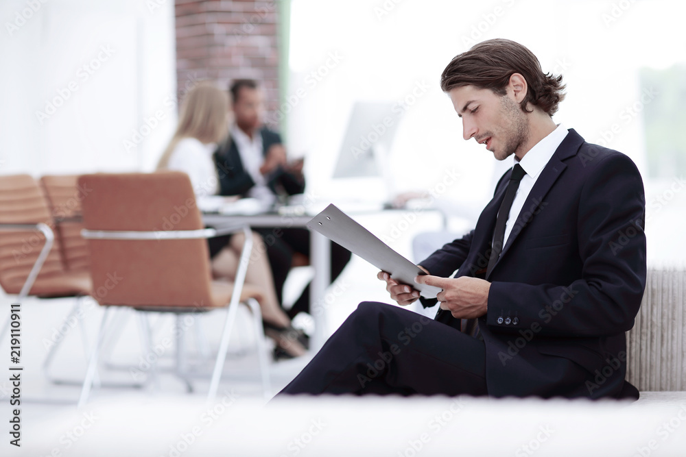 confident businessman studying the document in his office confident businessman studying the document in his office