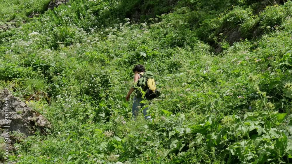 female hiker walking on a mountain trail female hiker walking on a mountain trail