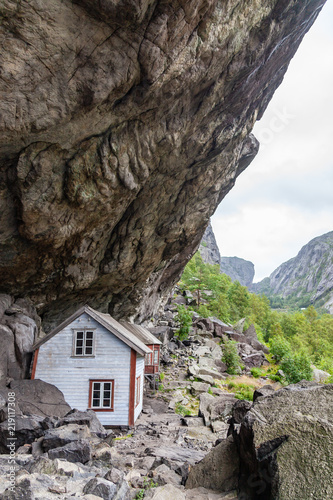 Old houses of ancient settlement below rock Helleren in Jossingfjord, Stavanger region, Southern Norway