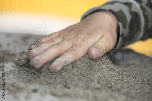 child's hand on the sand