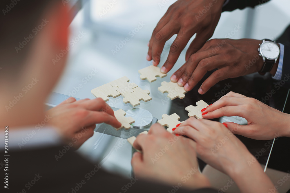 close up. business team assembling puzzle pieces. close up. business team assembling puzzle pieces.