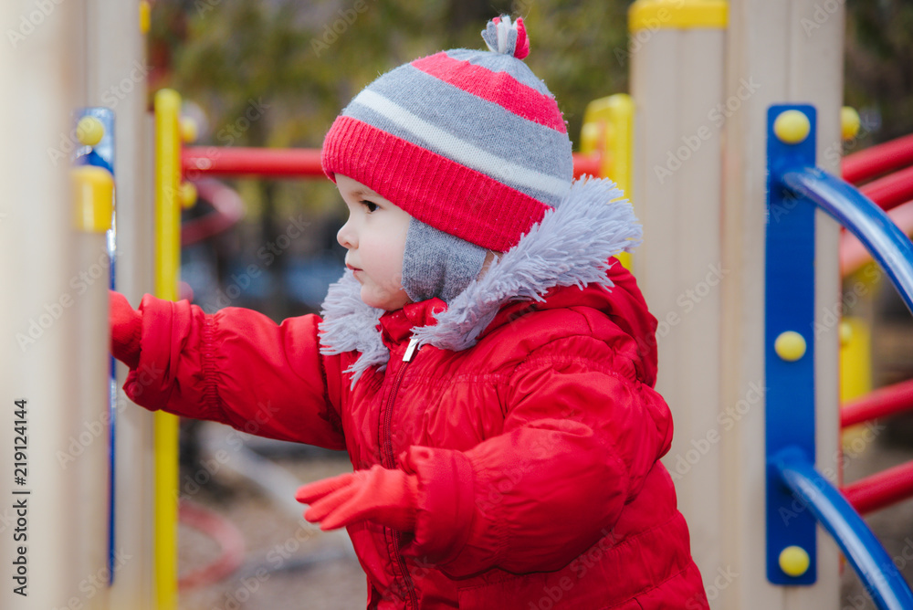 Obraz premium little kid is playing on the playground in the park